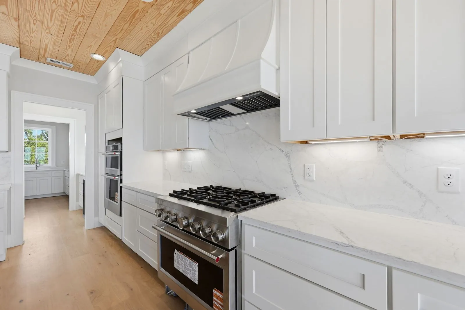 Range wall with custom hood and double wall ovens