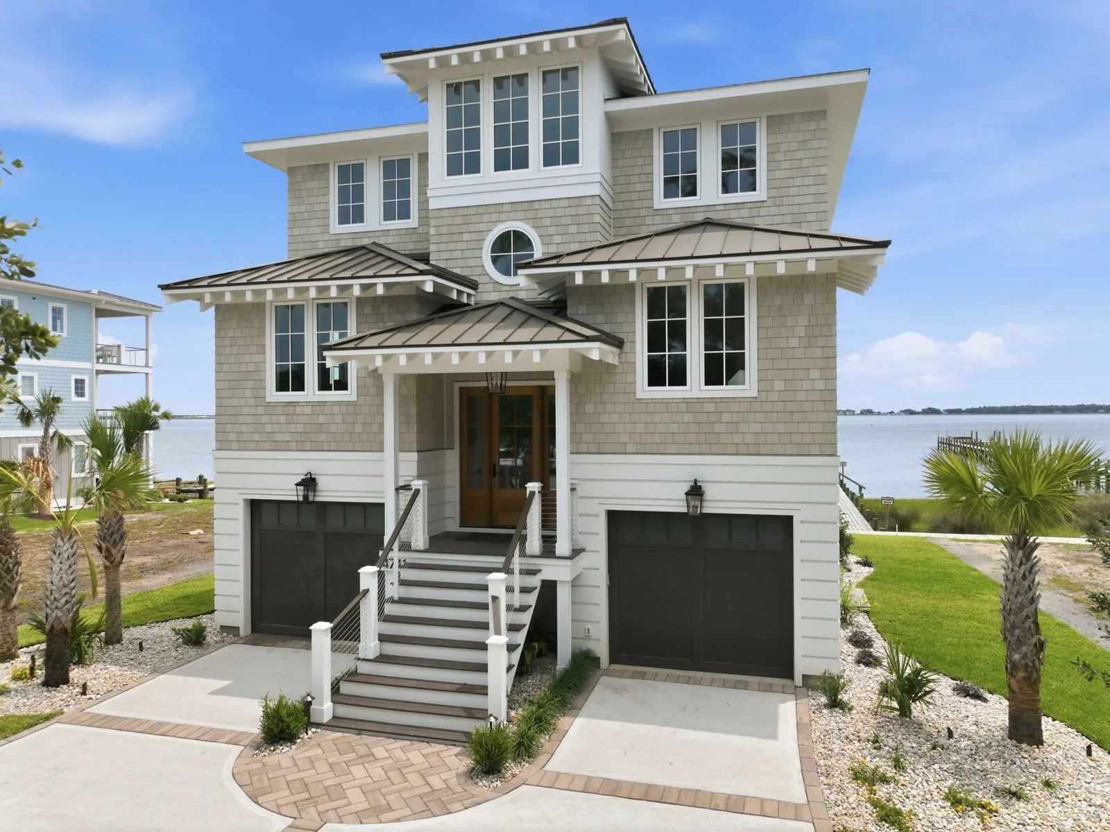 Front elevation of 4741 S Shore Drive with shake siding, standing-seam accent roofs and twin garages